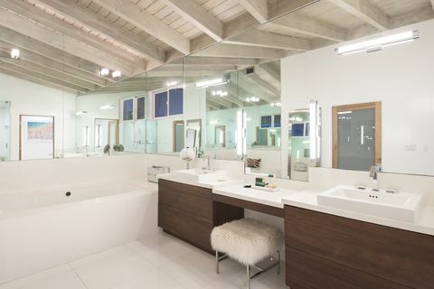 moderni kylpyhuone, jossa ruskeat kaapit ja suuri peili