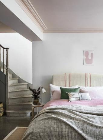 kāpnes ved uz guļamistabu ar rozā griestiem