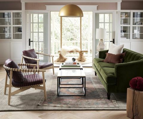 stue, grøn sofa, guld halvcirkel lysekrone, dobbelt sofabord