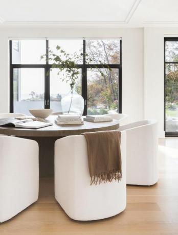 tavolo da pranzo in legno, sedie bianche, libri da tavolino