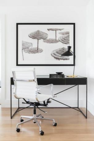 дерев'яна підлога, чорний письмовий стіл, білий стілець