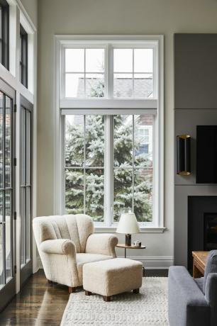 sillón blanco, chimenea, paredes color crema, alfombra color crema, suelos de madera