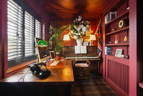 тамноцрвена радна соба са столом и клавиром