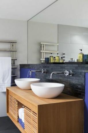 Waschtischunterschrank mit weißen Waschbecken und grauem Hintergrund