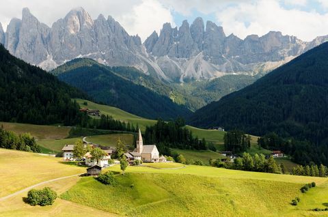 Odle(가이슬러) 산맥의 험준한 봉우리를 배경으로 하는 목가적인 발 디 푸네스의 여름 풍경과 이탈리아 사우스 티롤(South Tyrol)의 돌로미티(Dolomiti)의 푸른 잔디 계곡에 있는 빌리지 산타 마달레나(Village Santa Maddalena)의 교회