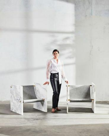 kobieta stojąca z dwoma krzesłami