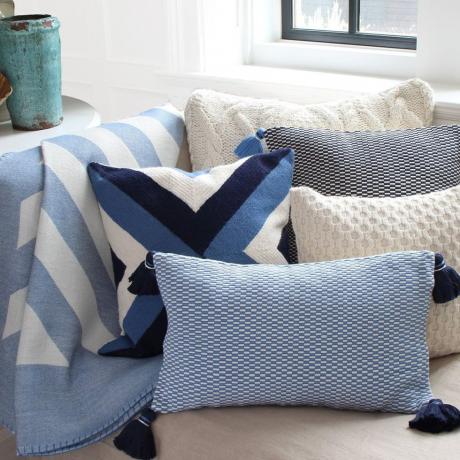 niebieskie narzuty i poduszki na kanapie