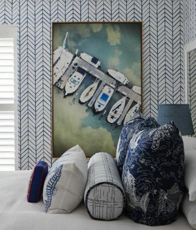 guļamistaba, karalienes gulta, dekoratīvie spilveni, baltas un zilas ģeometriskas tapetes