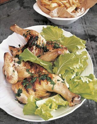tányér grillezett csirkével és leveles zöldekkel, valamint egy tál krumpli az oldalán