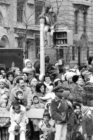 niño sentado encima de una señal de cruce en el desfile de acción de gracias de macys en 1974