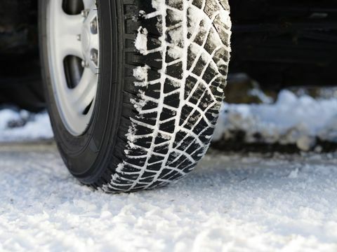Neumático cubierto de nieve en carretera nevada