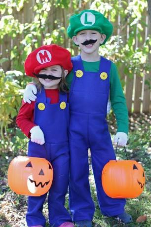 момче и момиче, облечени като Марио и Луиджи от братята Марио с големи фалшиви мустаци и сини гащеризони