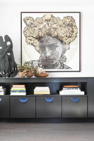 lemari kayu hitam, galeri seni dinding, vas besar, buku meja kopi