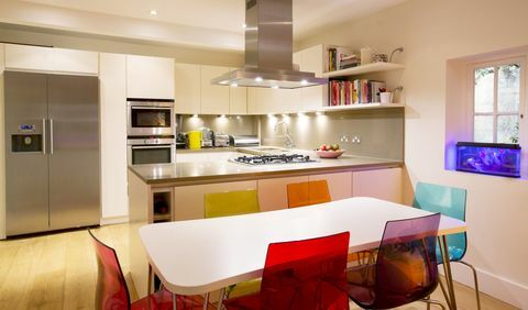 Moderna virtuve ar krāsainiem krēsliem pie pusdienu galda
