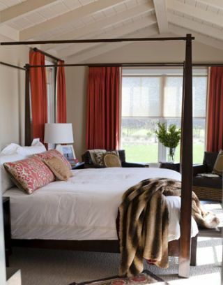 кровать с балдахином и красными шторами