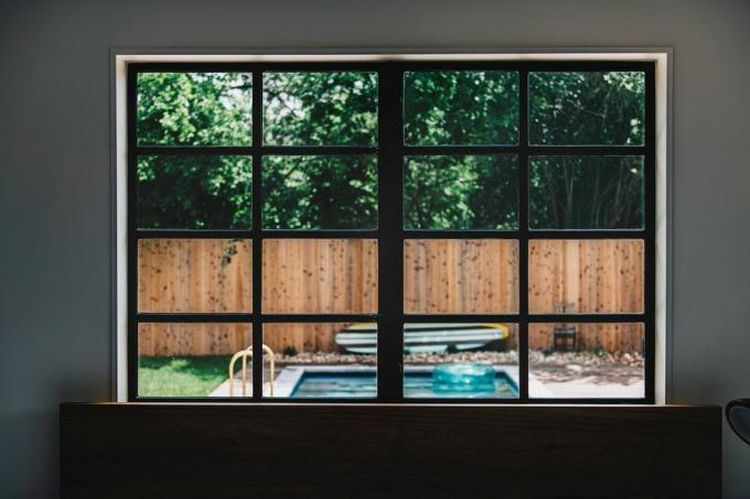 piscina en el patio trasero a través de una ventana moderna