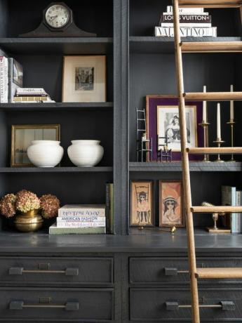 خزانة الكتب ذات اللون الرمادي الداكن مع الأشياء والسلم