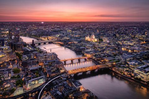 Skats no gaisa uz Londonas pilsētas ainavu ar Temzas upi krēslā