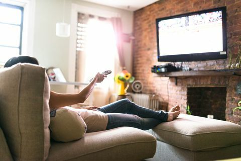 Женщина расслабляется онлайн на диване, читая документы