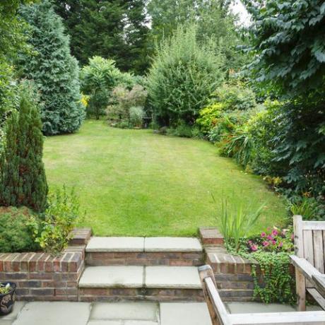 terrassenförmig angelegter und angelegter Garten in England Großbritannien mit Terrasse, Gras und Steintreppen