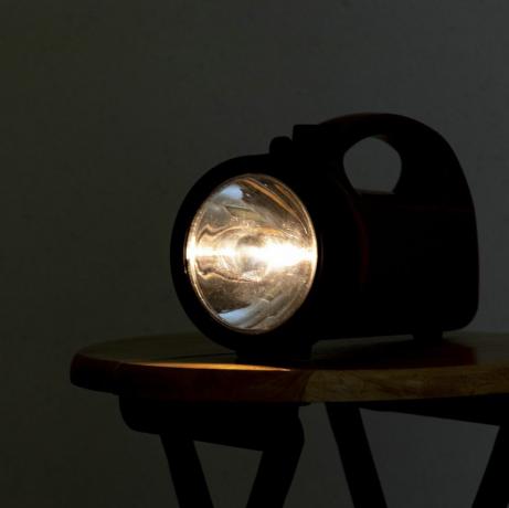 lampe de poche qui brille dans une pièce sombre