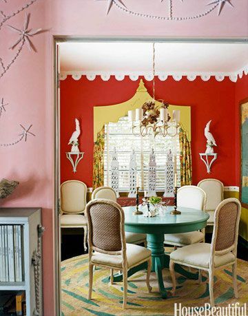 jedáleň s oranžovými stenami a tyrkysovým stolom