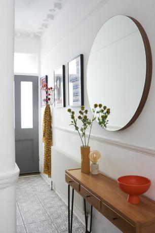 corridoio in casa con consolle e grande specchio circolare