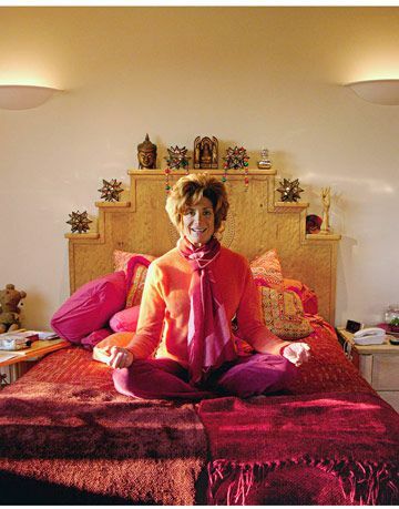 vrouw zittend op bed in yoga-positie