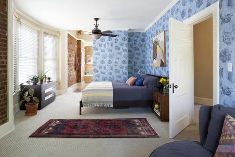 spálňa s modrými tapetami a tehlovými stenami
