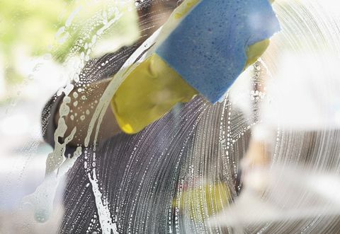 Muž umývajúci okno špongiou