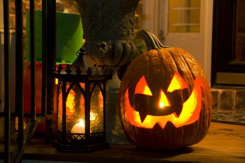 Calabaza de Halloween y vela en el porche
