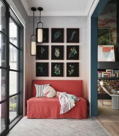 entrada, sofá vermelho, arte floral preta na parede