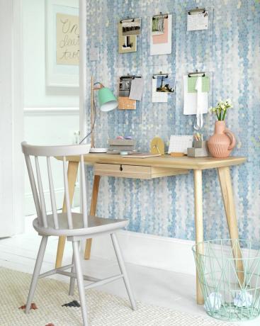 Weißer Stuhl und Holzschreibtisch an der Wand mit Bulldoggenklammern zum Aufhängen von Papier. Ziemlich praktisch. Ein Satz Klemmbretter aus Plexiglas hält die Unordnung unter Kontrolle und sorgt für eine künstlerische Darstellung in einem Arbeitsbereich
