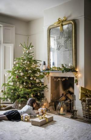 Navidad en casa con árbol de Navidad, chimenea y regalos.