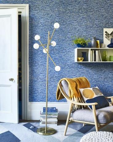 obývací pokoj s modrou texturovanou tapetou a stojací lampou se šesti kulatými bílými světly