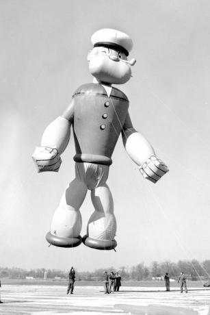 Popeye, jūrnieks, parādes balons izliek muskuļus, kad viņš gatavojas lidot