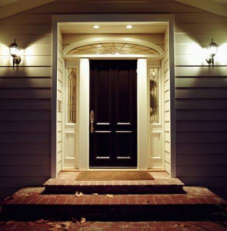 Входна врата на къщата със светлини през нощта