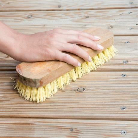 يد أنثى تنظف السطح الخشبي
