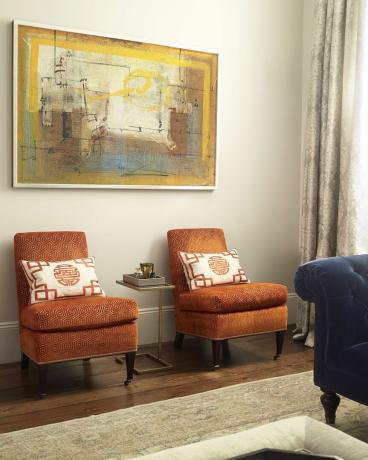 दो नारंगी कुर्सियों के ऊपर अमूर्त पेंटिंग