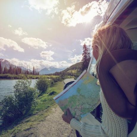 mladá žena sa pozerá na cestovnú mapu blízko horského jazera