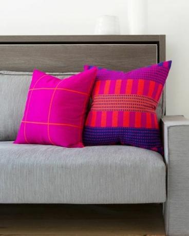 Almofadas rosa neon em sofá cinza