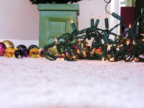 Kerstversiering, inclusief lichtjes en kerstballen, op de vloer
