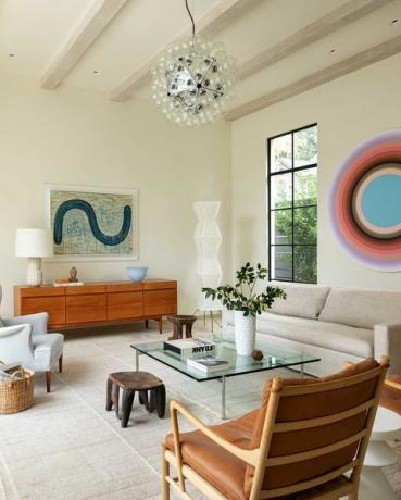 nappali, krémfestett falak, fa mennyezeti gerendák, fa oldaldeszka, krémszínű kanapé kanapé, műalkotások