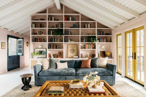 dzīvojamā istaba, atpūtas zona ar rozā sienām, zils dīvāns, brūns ādas pufs, dzeltenas franču durvis