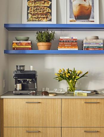 kaffebar med espressomaskin och kokböcker i hyllorna