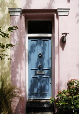 blå hoveddør, pastellrosa ydre af traditionel britisk boligbygning